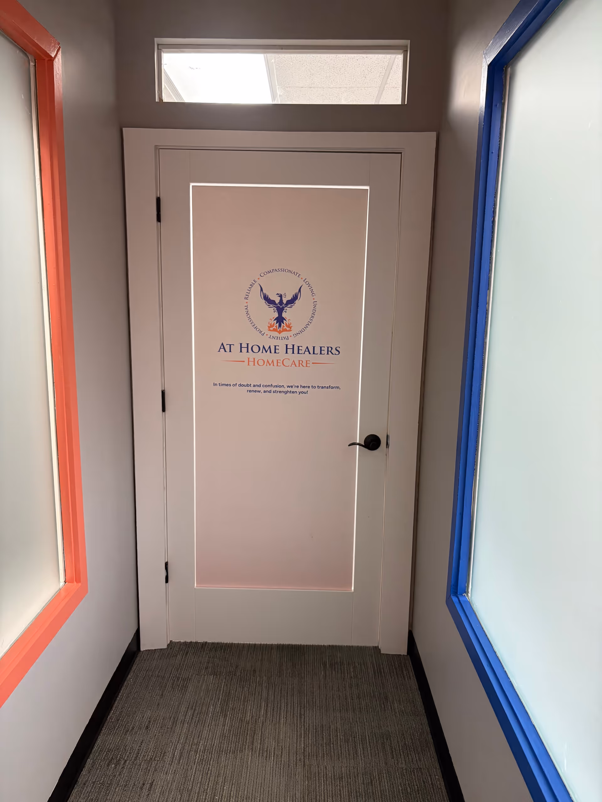 White interior door bearing At Home Healers Home Care logo in a narrow hallway.