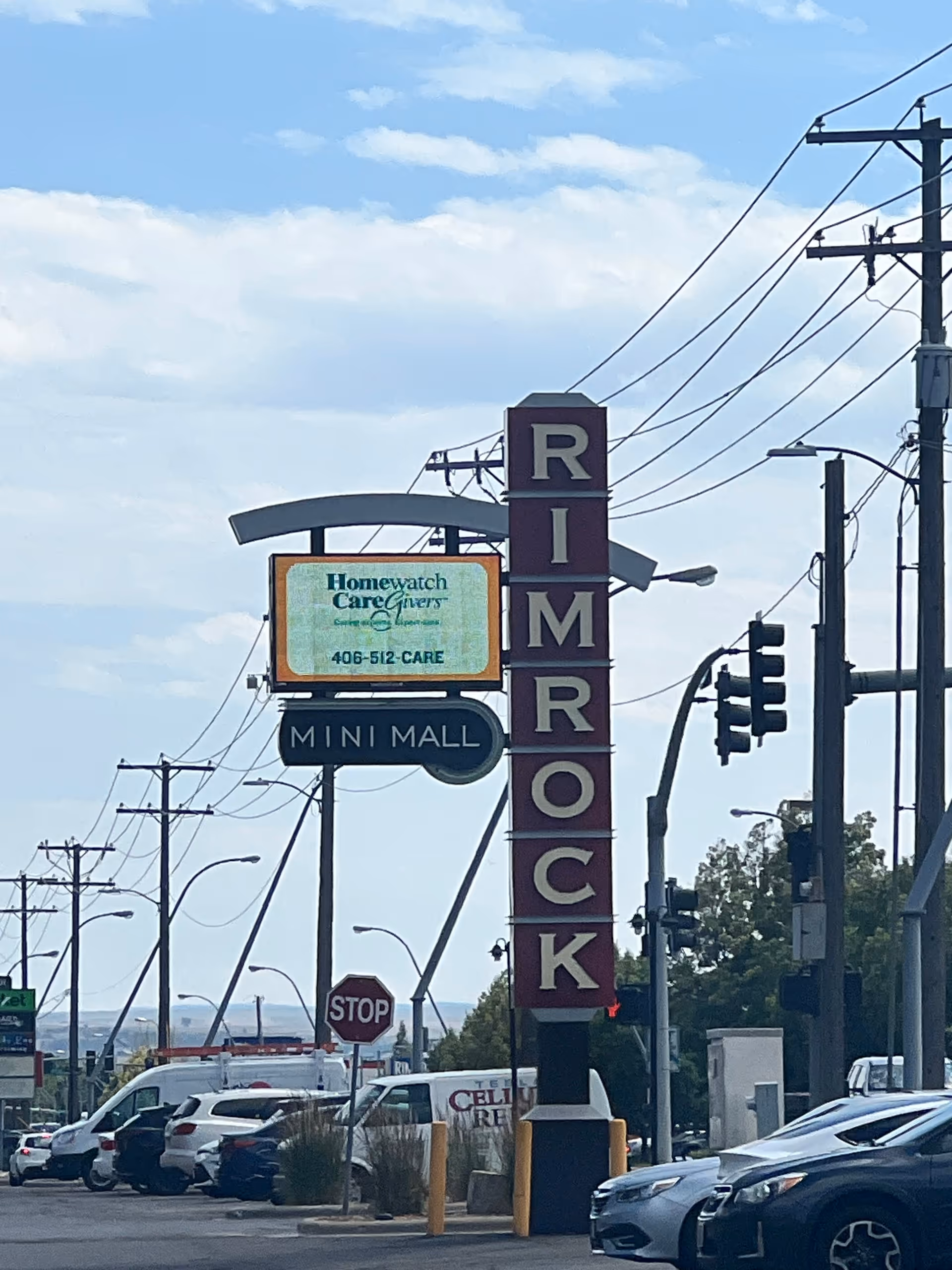 Outdoor street scene featuring Homewatch CareGivers sign beside Rimrock storefront sign.
