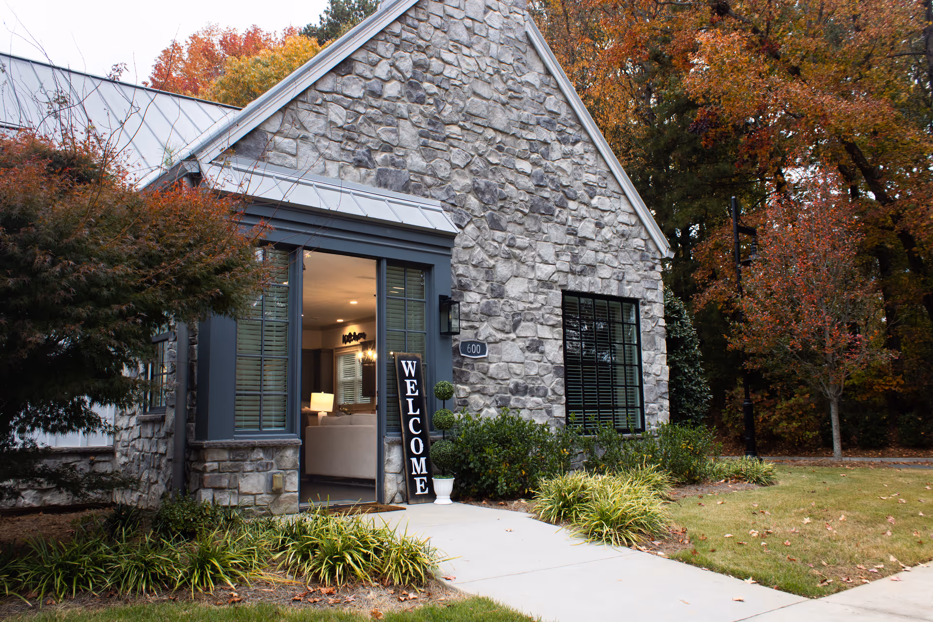 Stone-clad facility entrance with a vertical WELCOME sign beside the doorway.