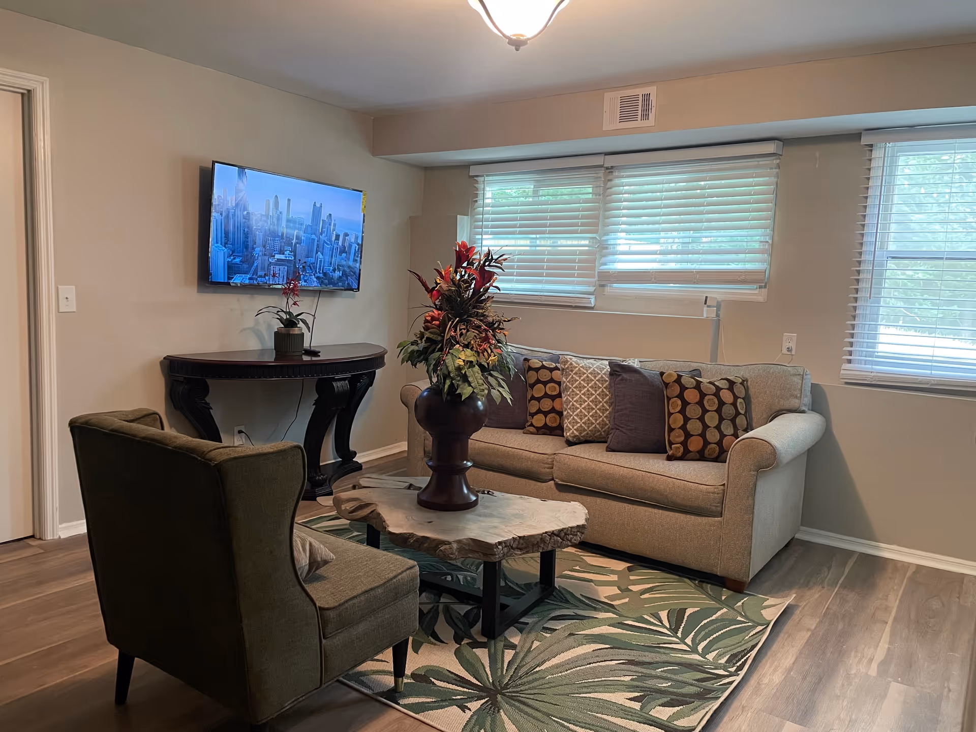 Living room in Farax Personal Care Home with sofa, chairs, TV, and rug.