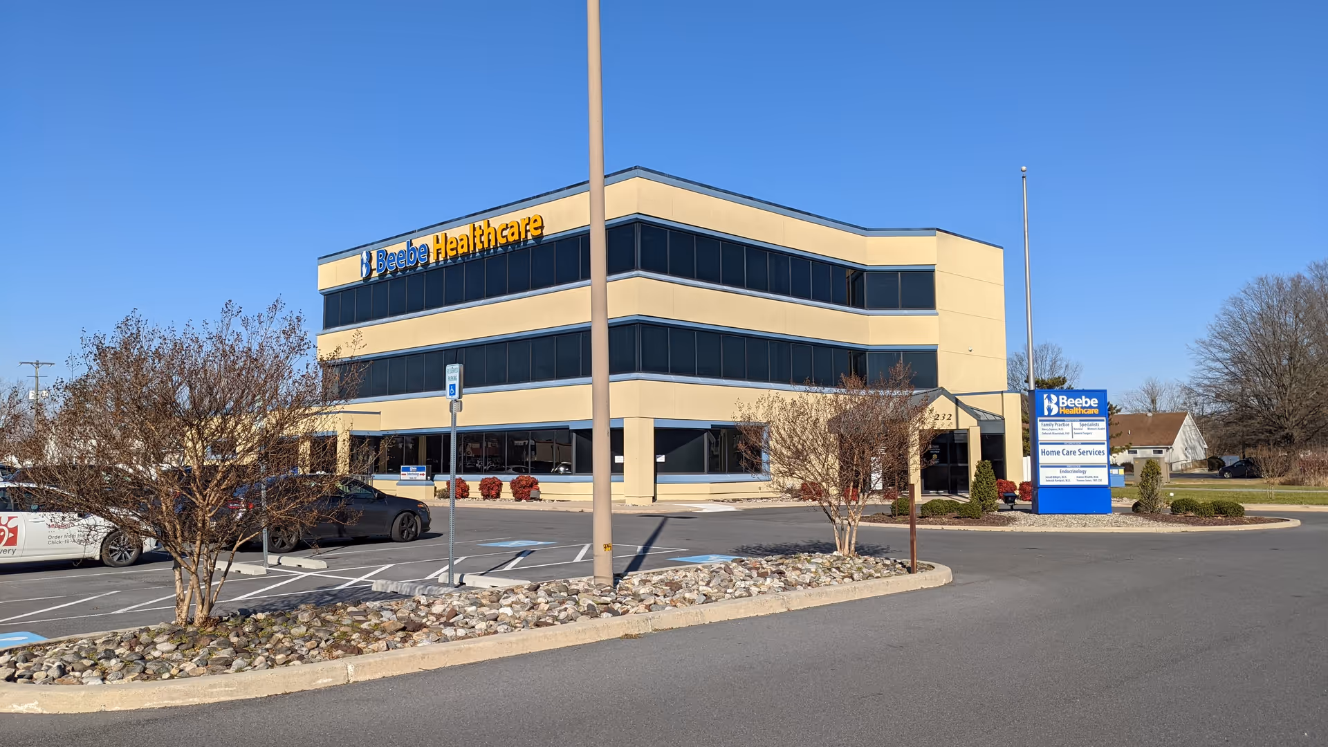 Beebe Healthcare building exterior with parking lot and main entrance sign.