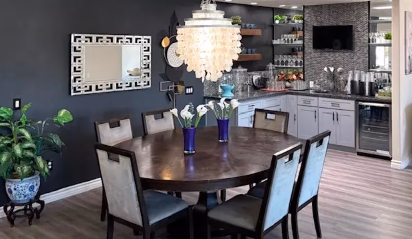 Round dining table with six chairs in a modern kitchen and dining area.