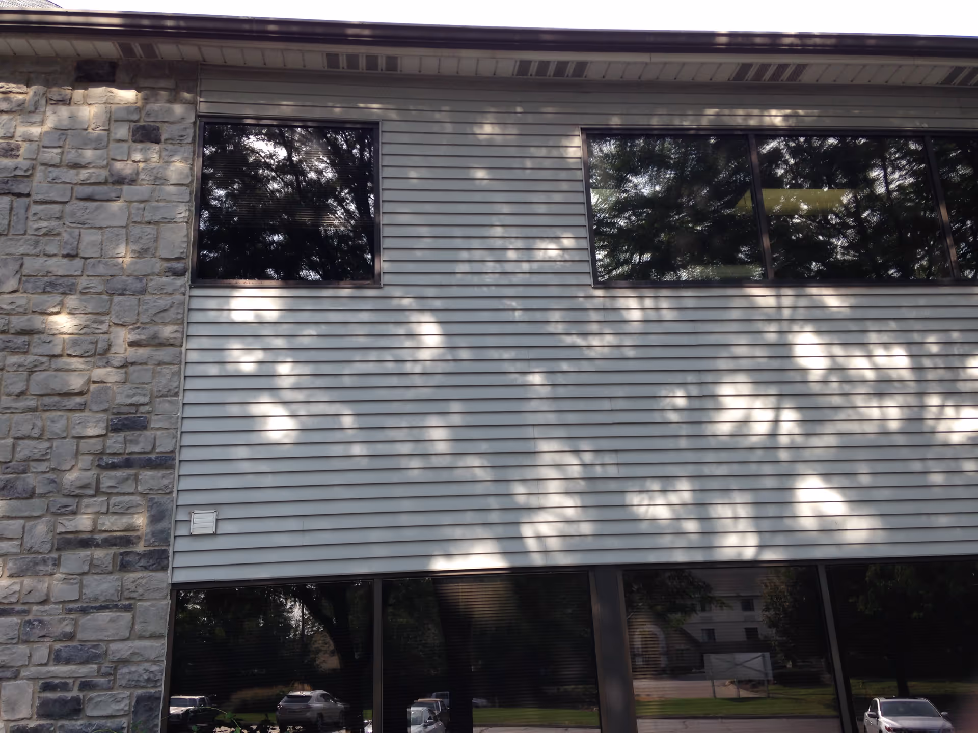 Exterior view of a senior living facility wall with windows and stone accents.