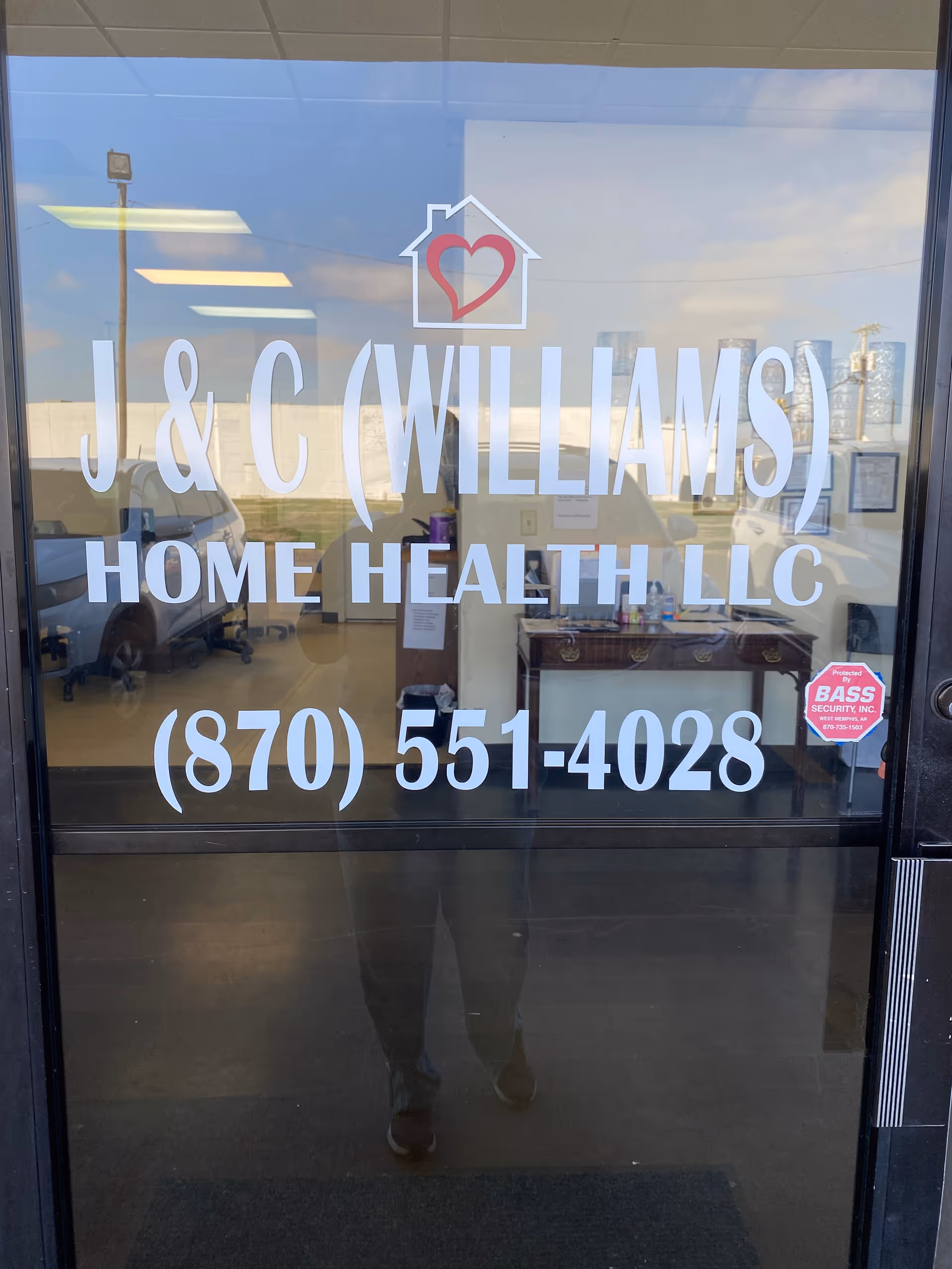 Glass door signage displays J&C Williams Home Health LLC name and phone number.