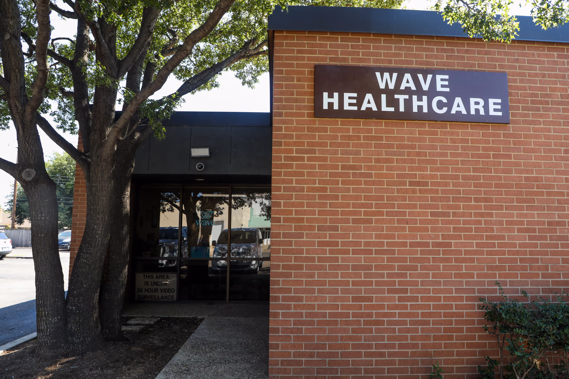Brick Wave Healthcare facility entrance with glass doors and large sign