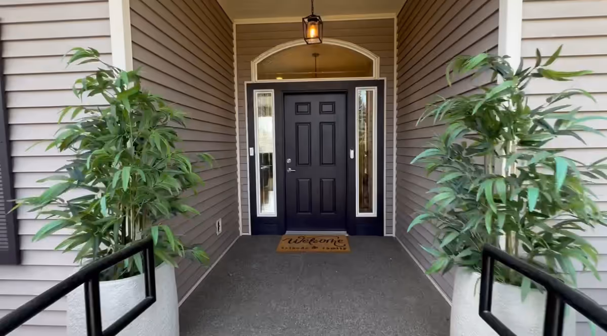 Front entrance of Kings and Queens Adult Family Home 2 with potted plants.
