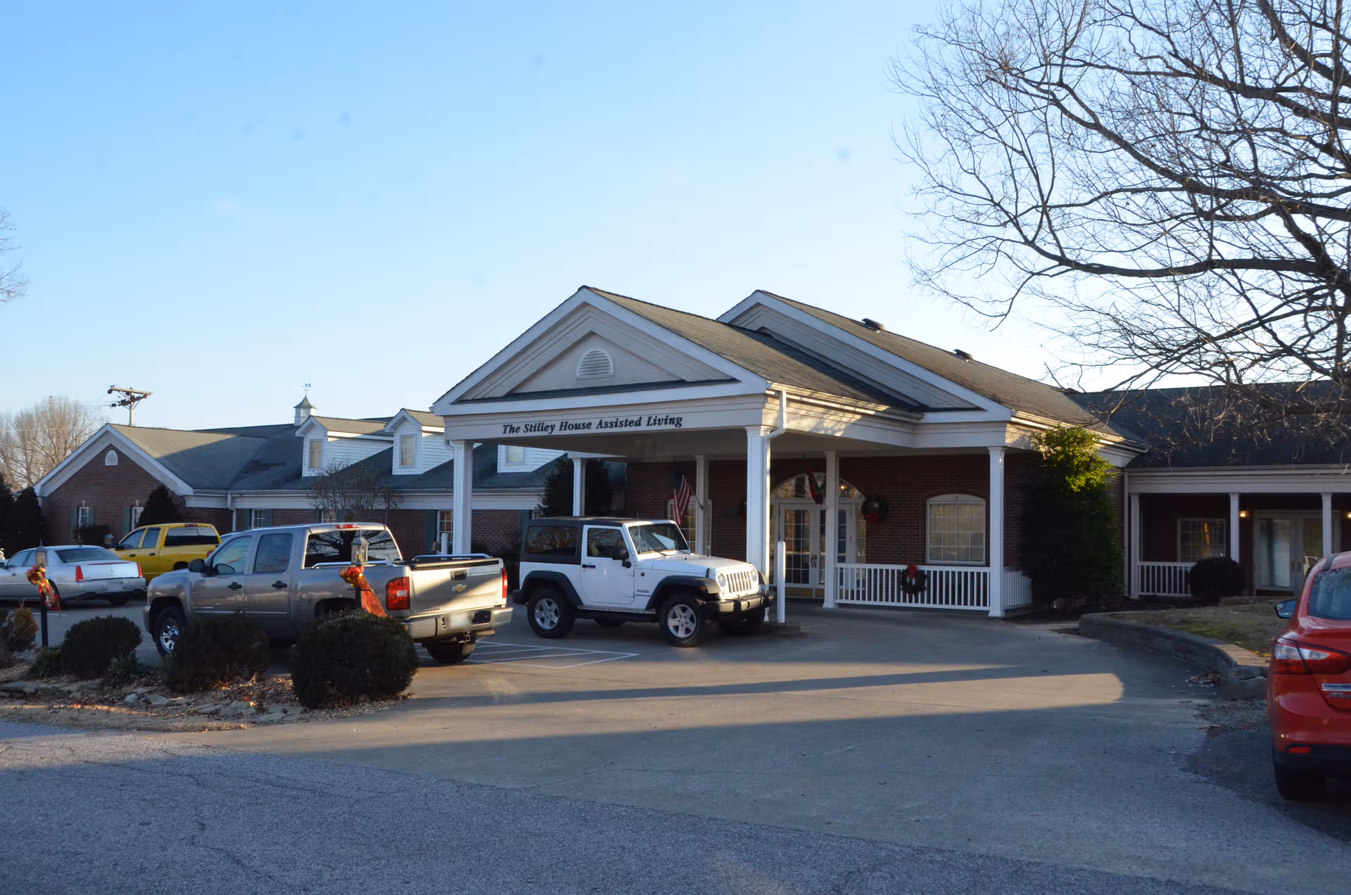 The Stilley House Assisted Living front entrance with cars in the parking lot