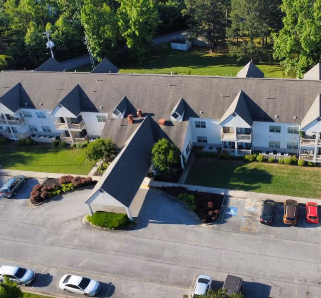 Aerial view of Wood-Lawn Heights senior living campus with multiple wings, parking, and trees.