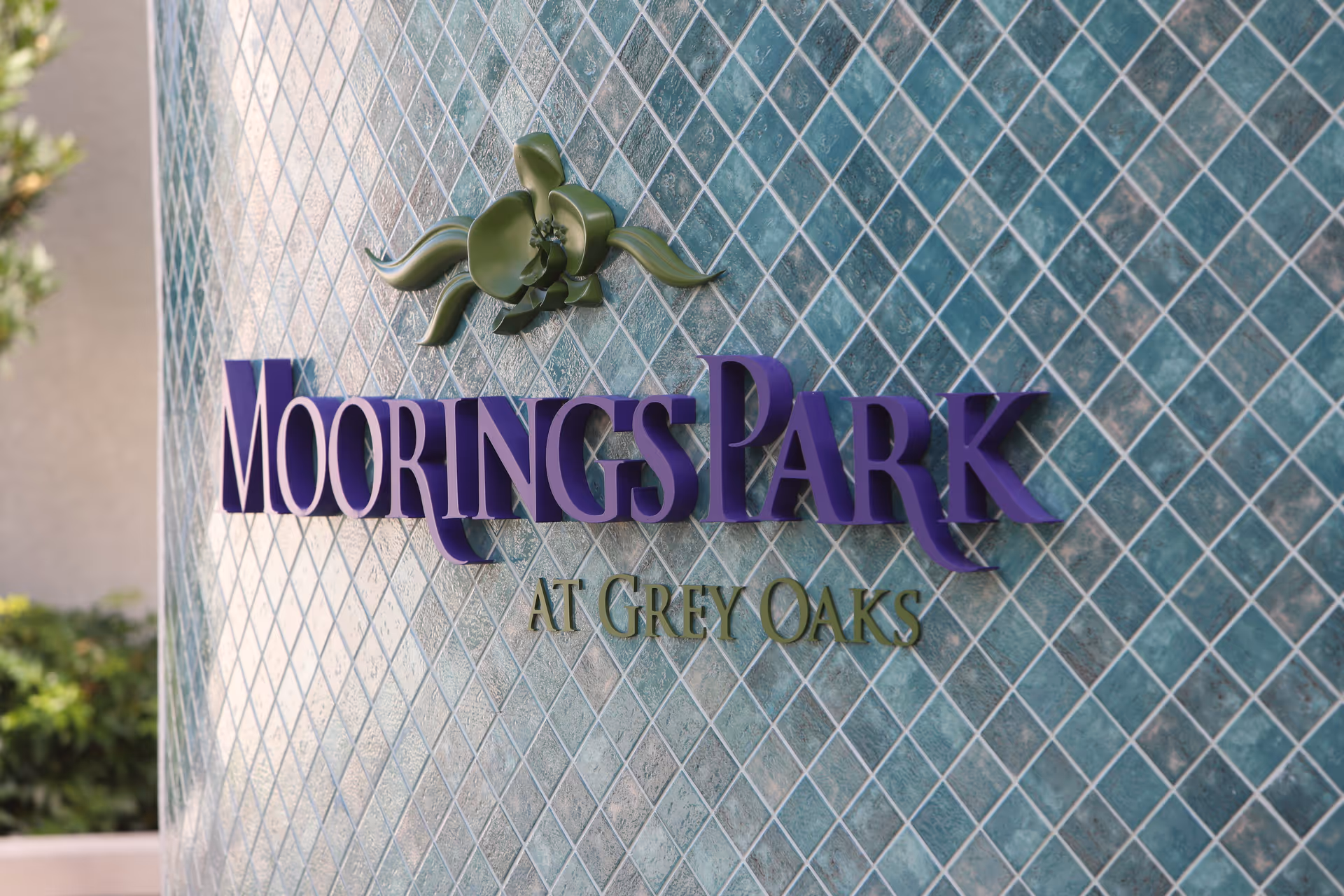 Moorings Park at Grey Oaks sign mounted on a blue tiled exterior wall.