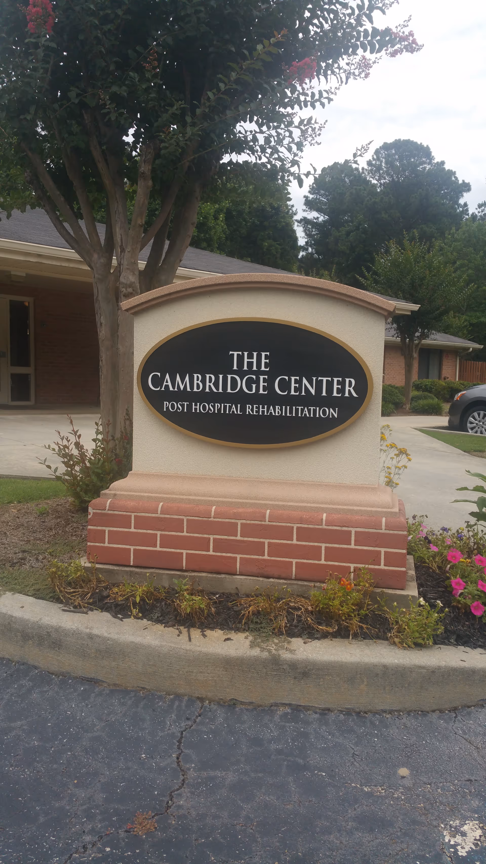 Exterior view of The Cambridge Center sign with landscaped surroundings and brick base.