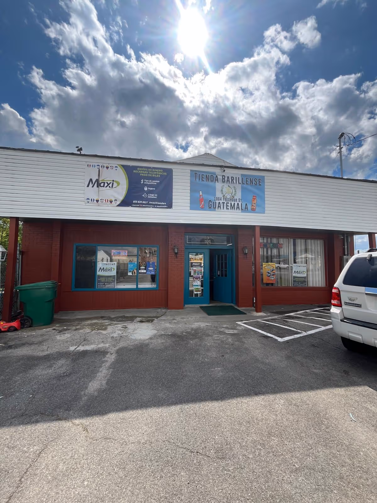 Exterior view of a small storefront with blue door and visible signs.