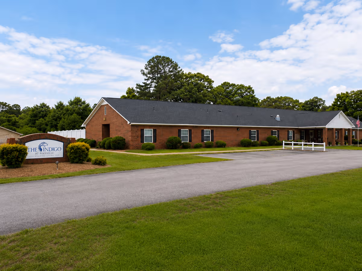 The Indigo at Pikeville exterior: brick building, sign, shrubs, and a grassy front lawn.