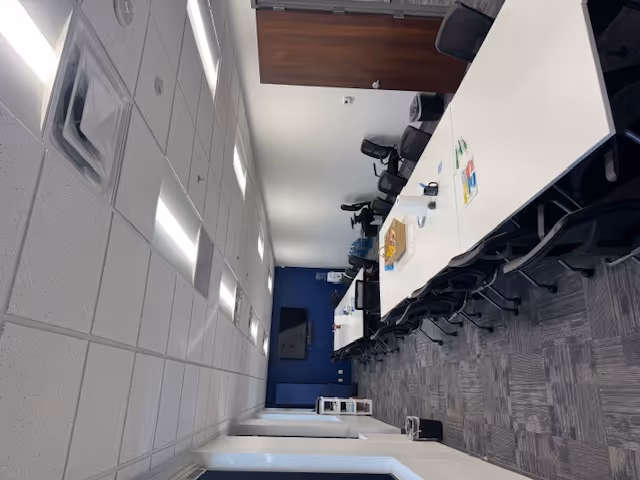 Long conference table with chairs in a bright, modern office meeting room.