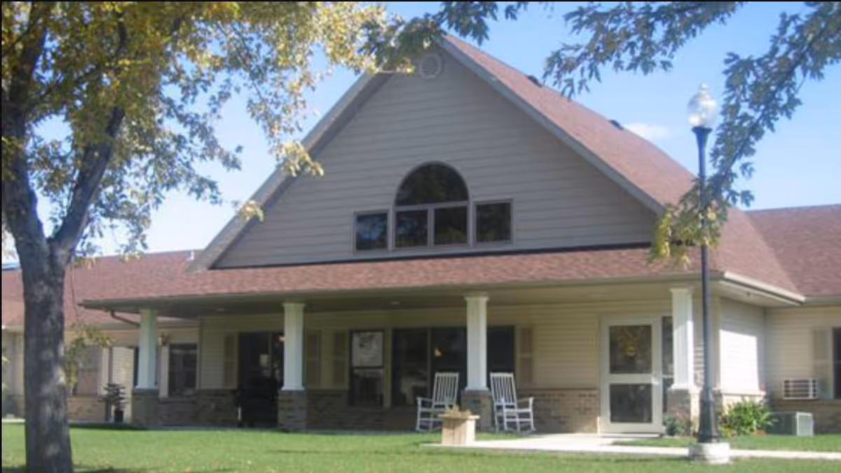 Front view of Grace Village retirement facility with porch and rocking chairs.