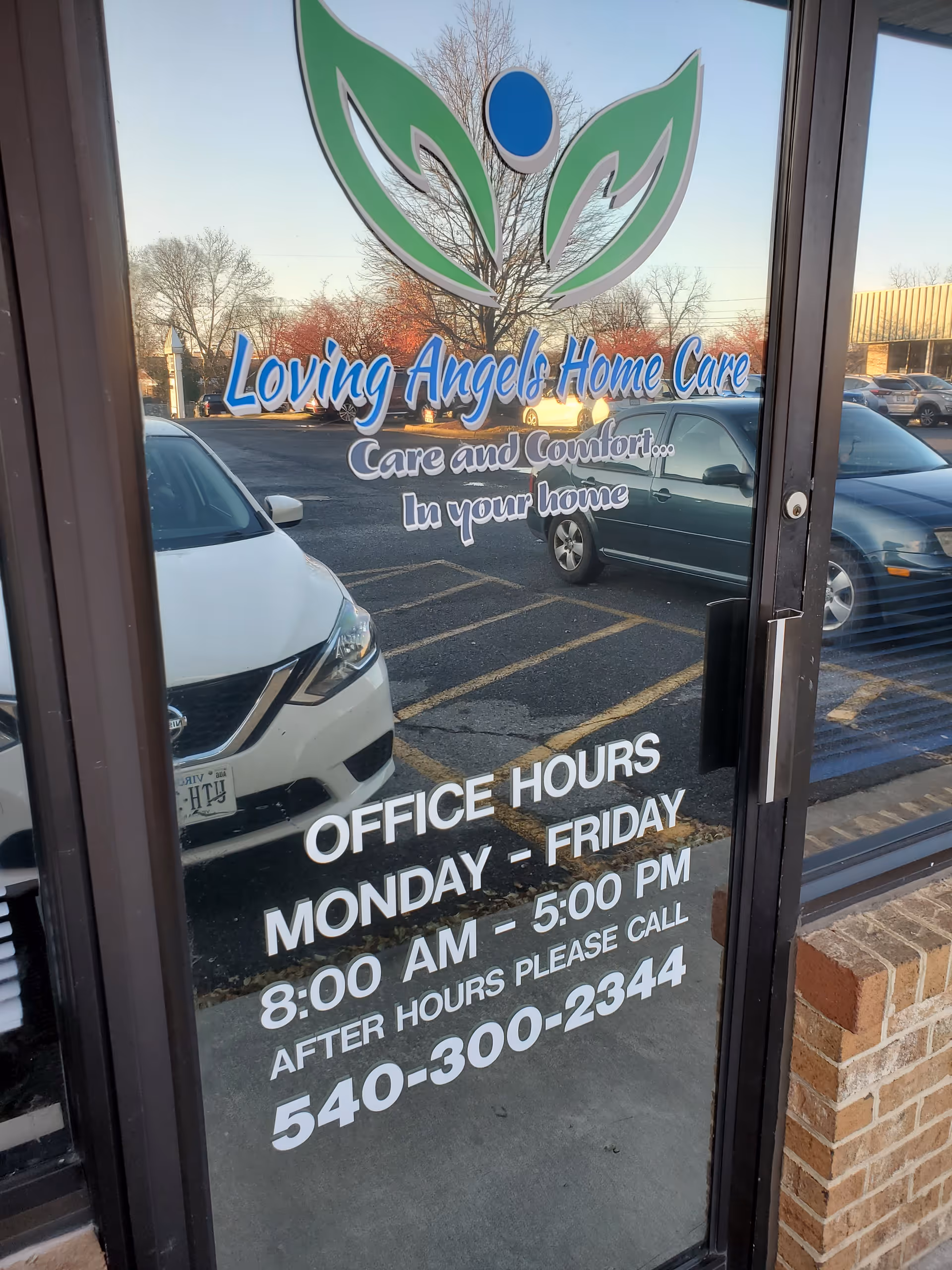 Glass storefront door for Loving Angels Home Care with logo and hours visible