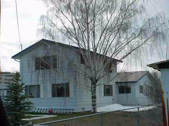 White two-story retirement home exterior with leafless tree and snow on the ground.