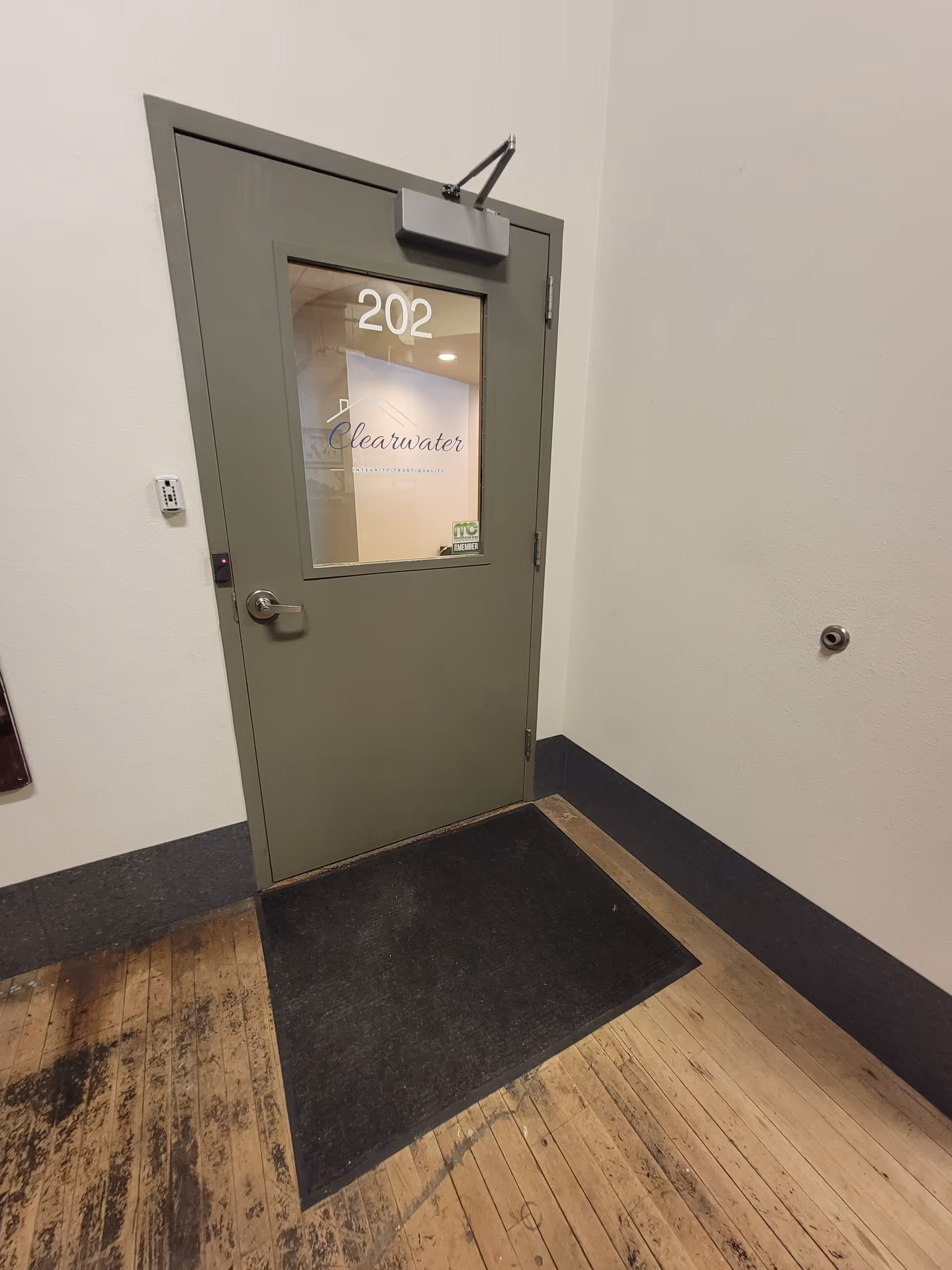 Interior hallway with a green door labeled 202 and Clearwater Assisted Living logo visible.