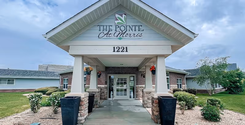 Front entrance of The Pointe at Morris senior living facility with a covered walkway.
