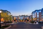 Exterior of Evergreens at Columbia Town Center showing brick buildings, driveway, and illuminated entrance.
