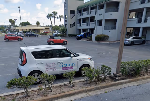 Exterior view of Granny NANNIES senior home care building with parked cars