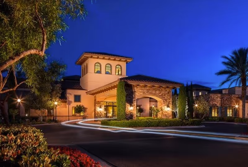 Night exterior of Las Ventanas at Summerlin with a lit entrance and circular driveway.