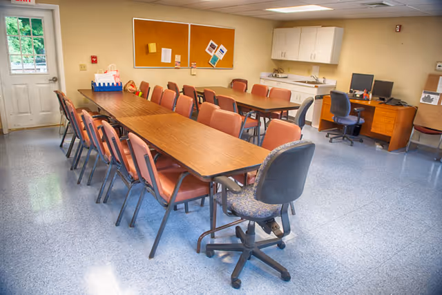 Long table with chairs in a bright senior dining room.