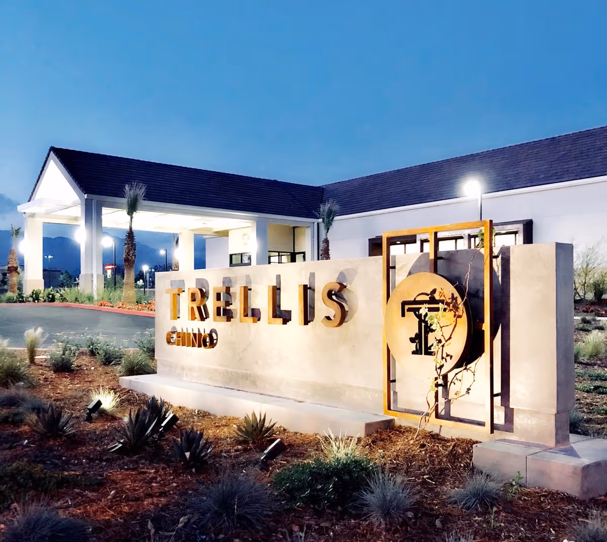 Exterior view of Trellis Chino facility entrance with illuminated sign and landscaping.
