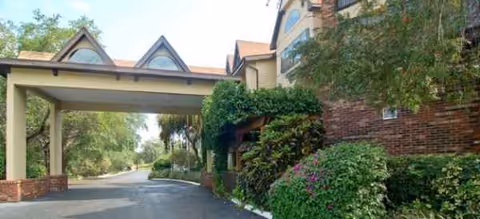Exterior view of Brookdale Sarasota Midtown entrance with brick building, covered driveway, and greenery.