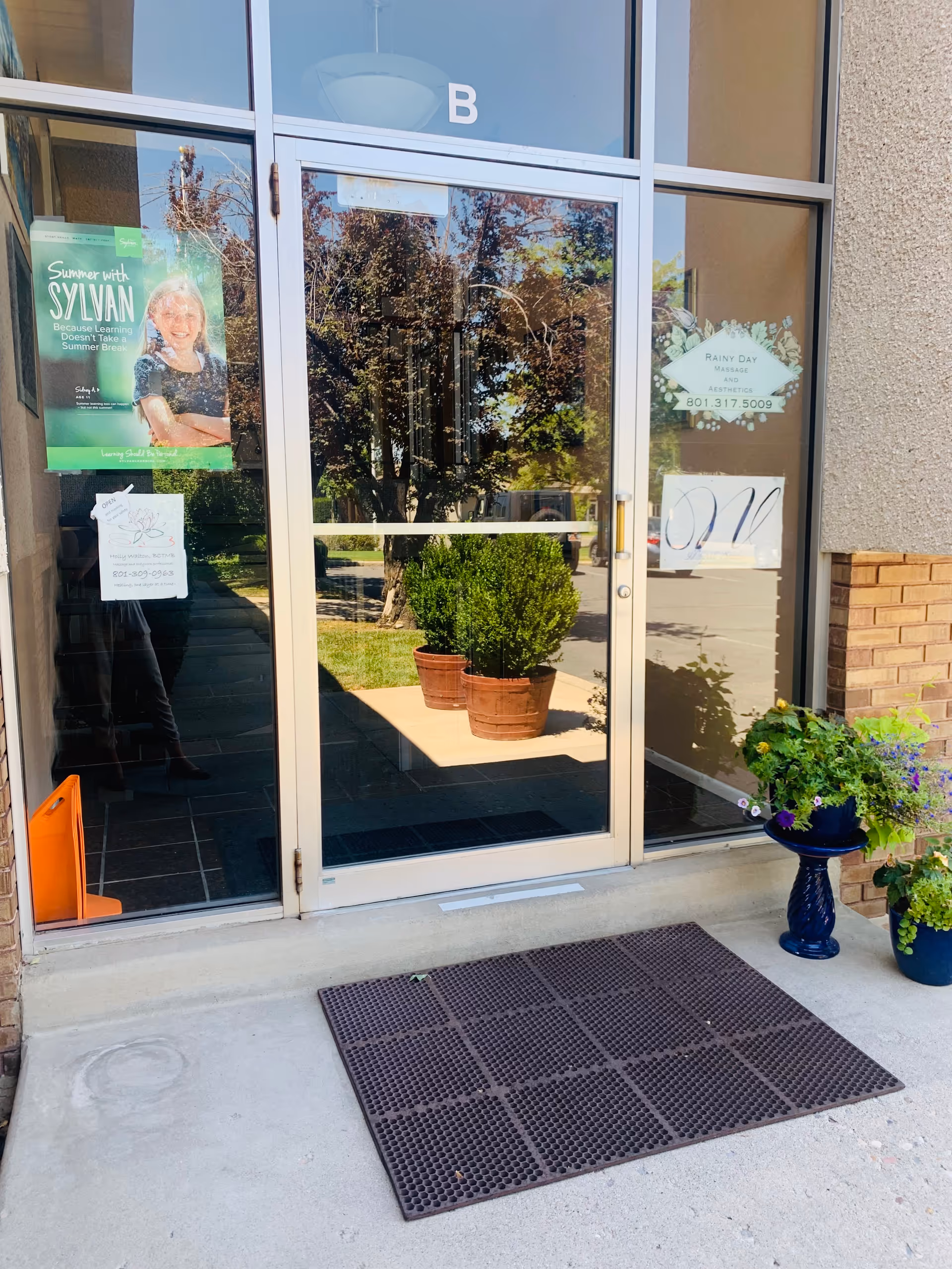 Glass entrance doors of Everest Home Health and Hospice building, with potted plants outside.