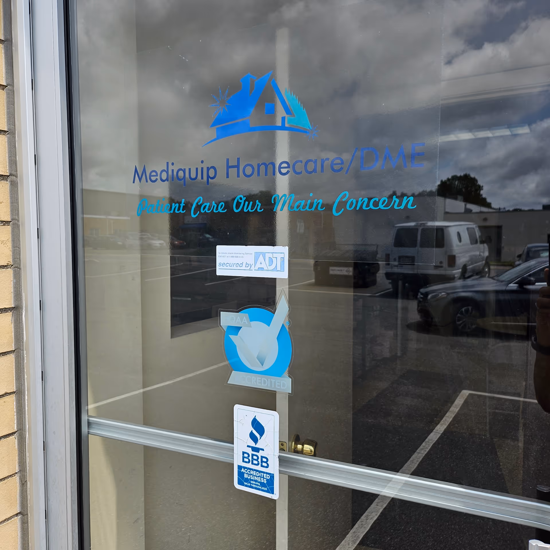 Glass entrance door shows Mediquip Homecare/DME branding and security stickers