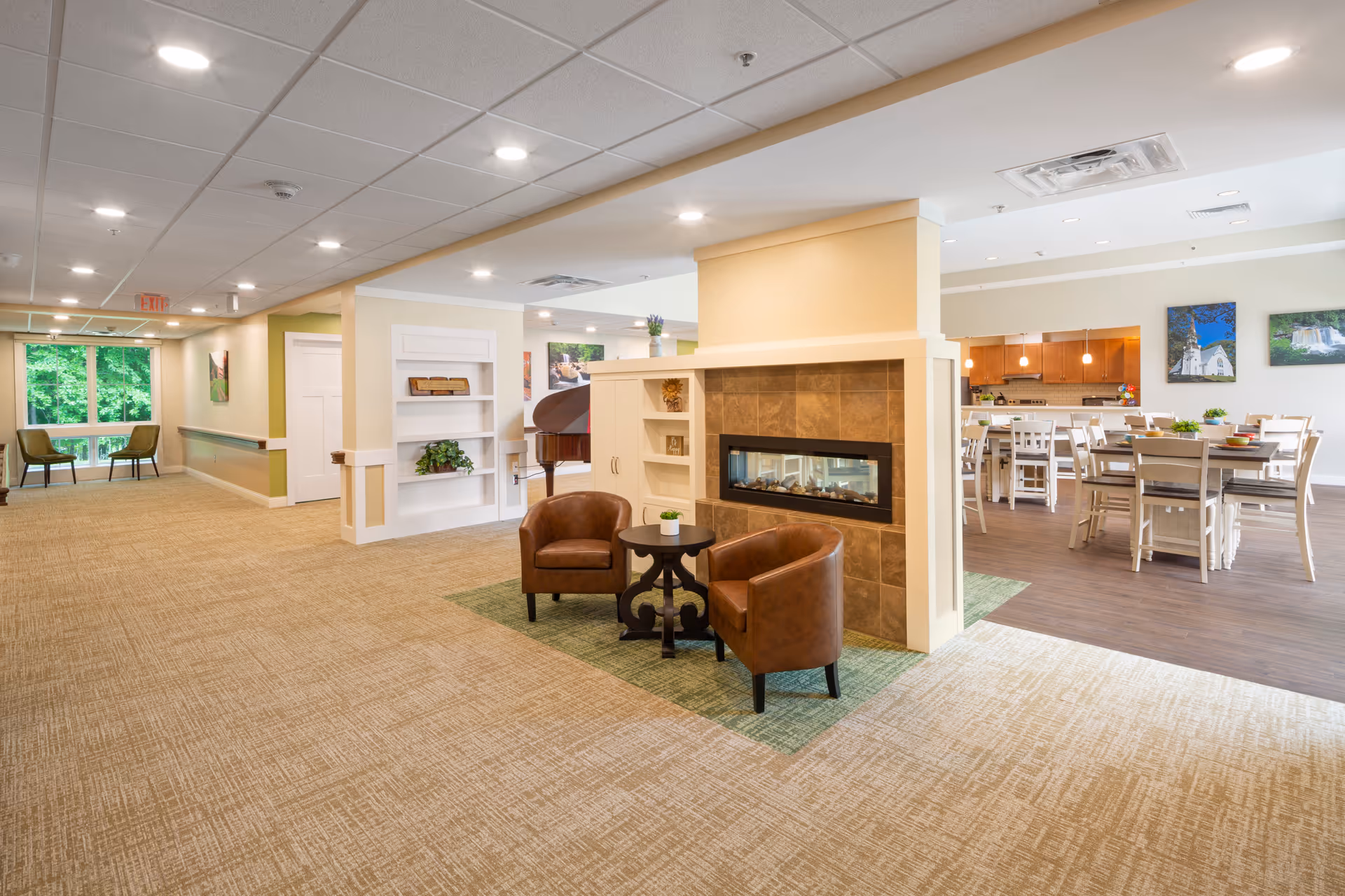 Spacious senior living lounge with fireplace, seating, and open dining area.