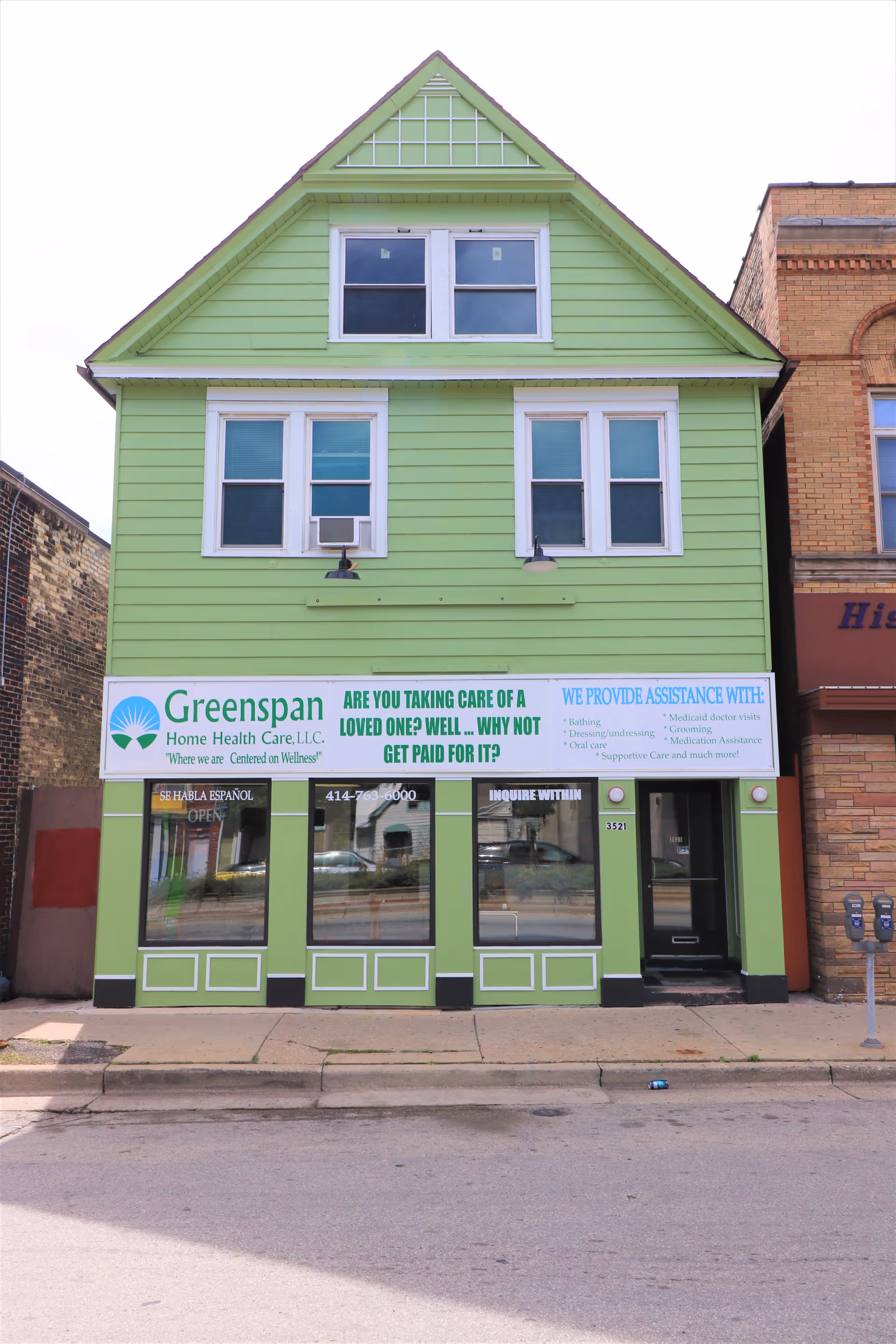 Two-story green storefront building with Greenspan Home Health Care sign.