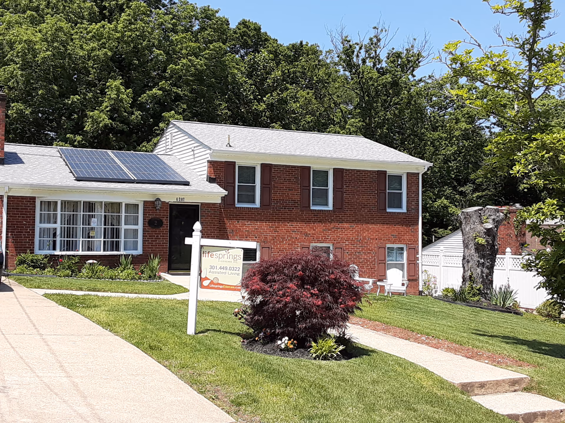 Lifesprings Eldercare II building exterior: brick, solar panels, front yard, sidewalk, and sign.
