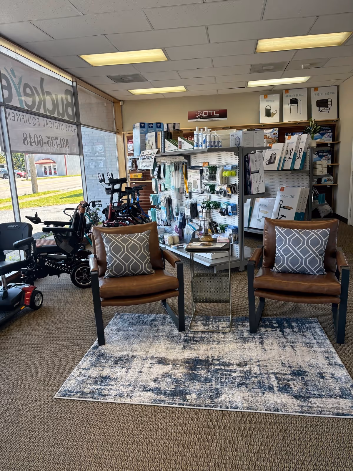 Two brown chairs with patterned cushions sit beside a small table in a medical supply showroom.