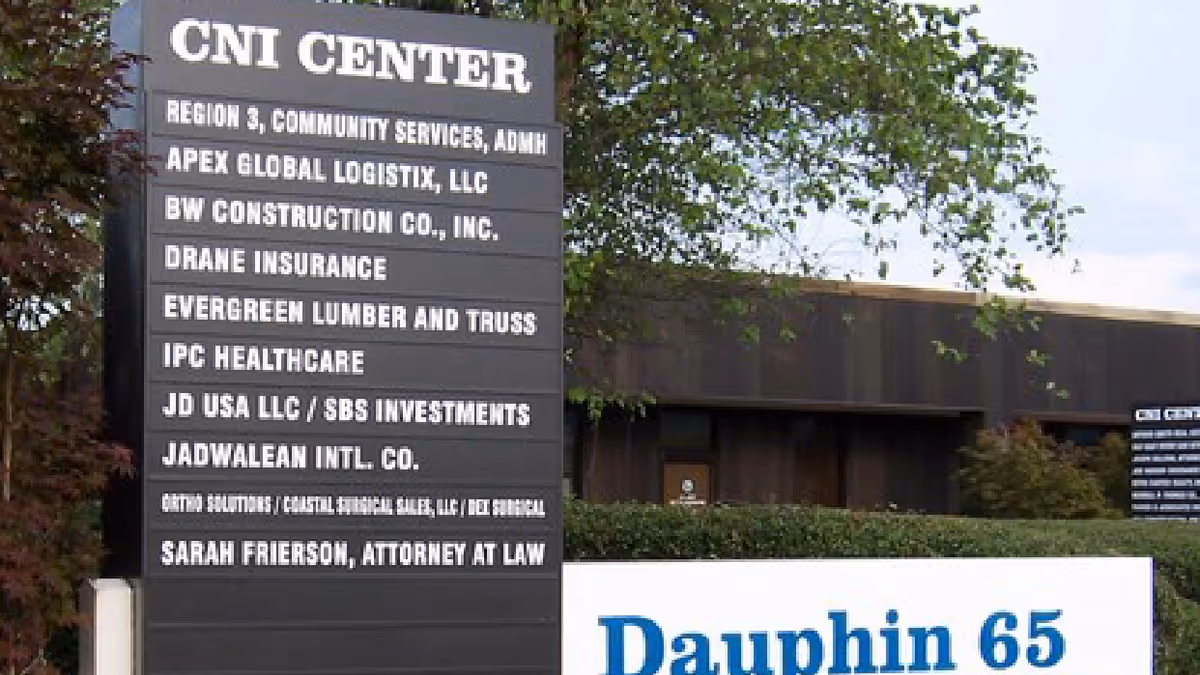 Exterior view of a building with a tall signboard listing tenants.
