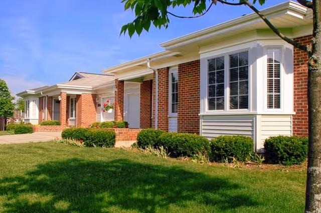 Exterior view of Covenant Living at the Holmstad with brick facade, bay windows, and landscaped lawn.