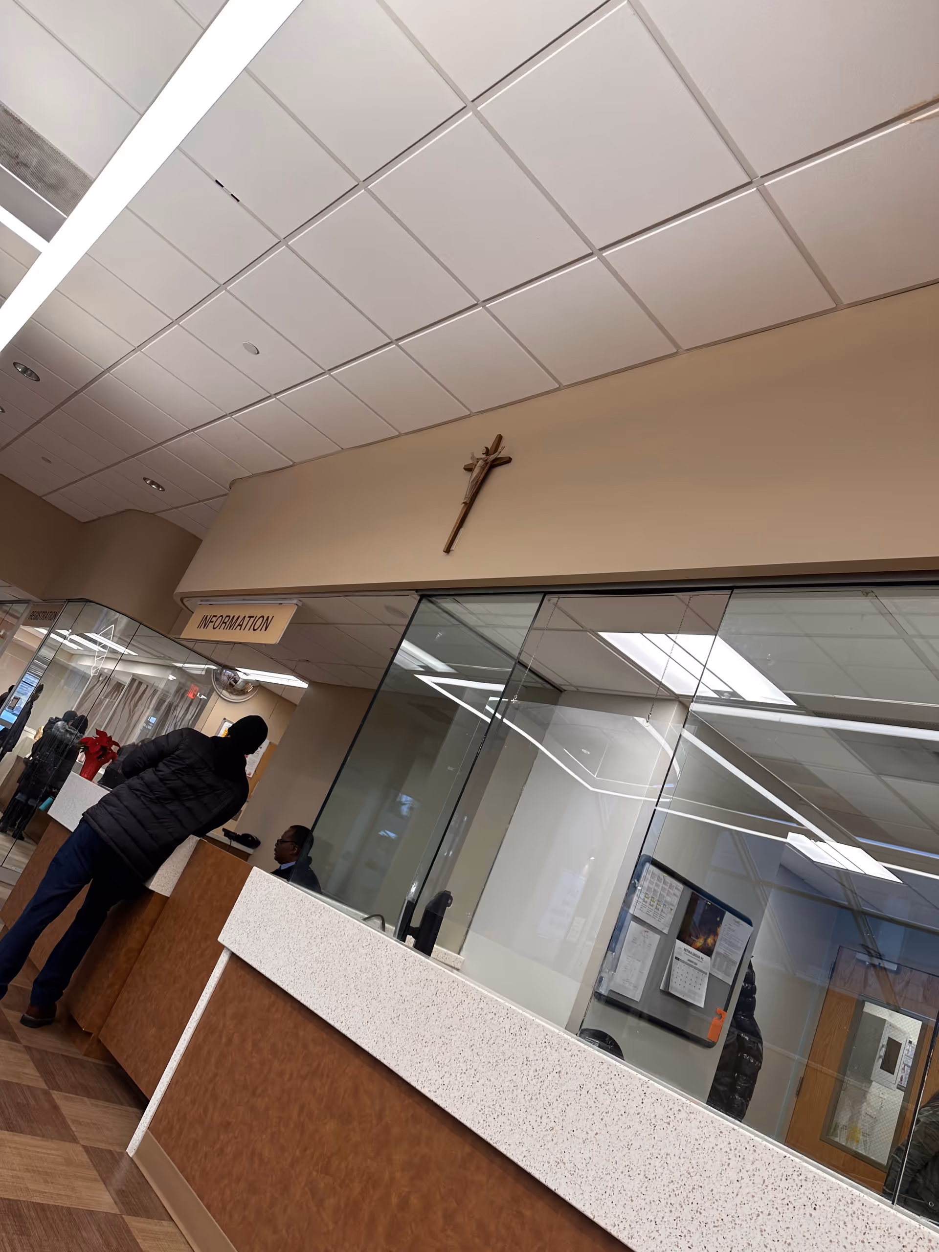 Inside a clinic reception area with information desk and glass partitions.