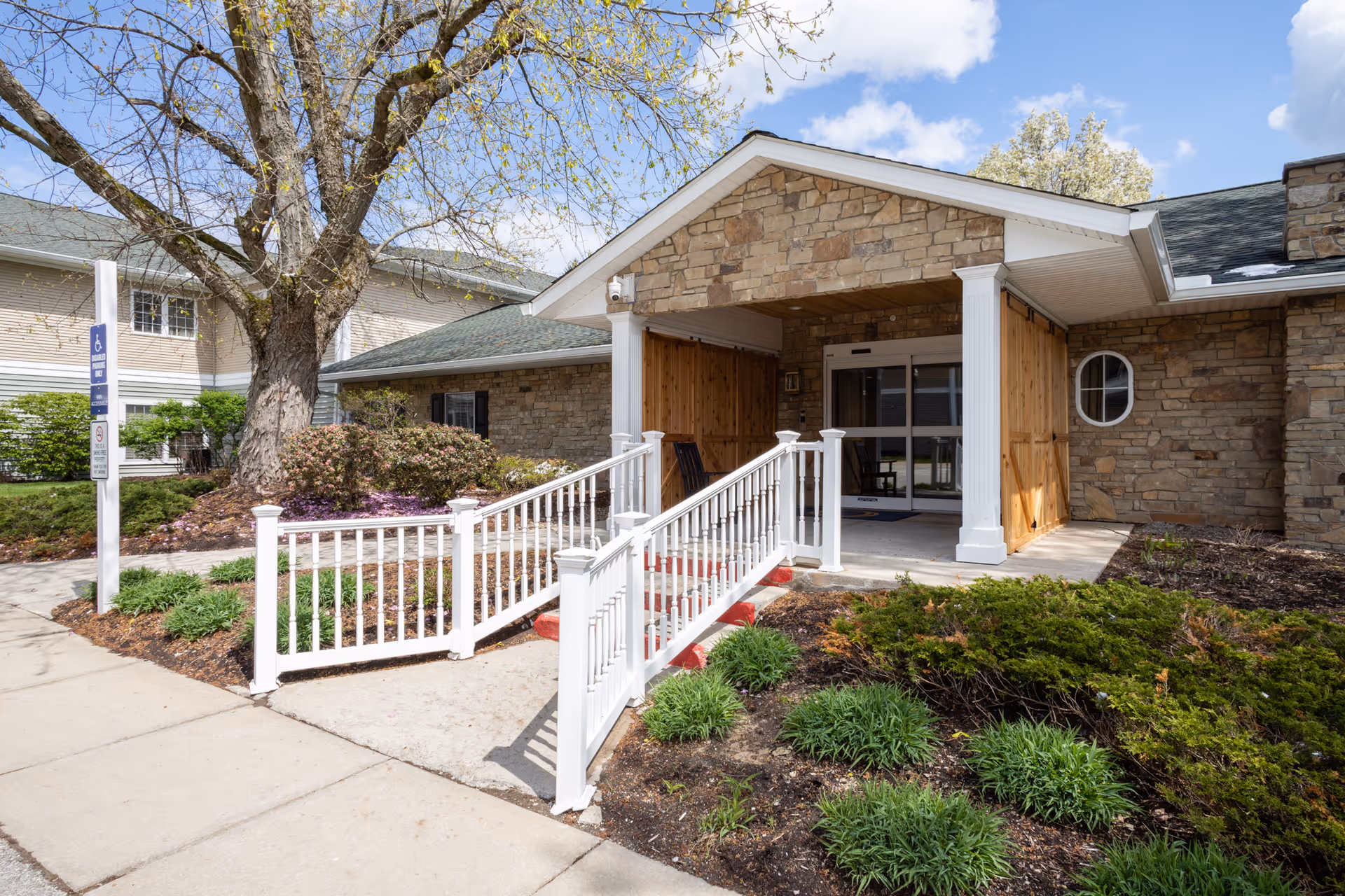 Front entrance of Briar Hill Health Care Residence with stone exterior and white railing.