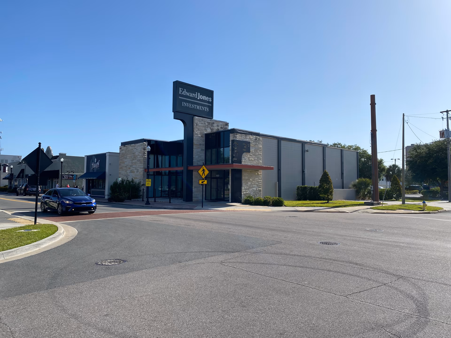 Modern commercial building along a sunny street with Edward Jones Investments sign
