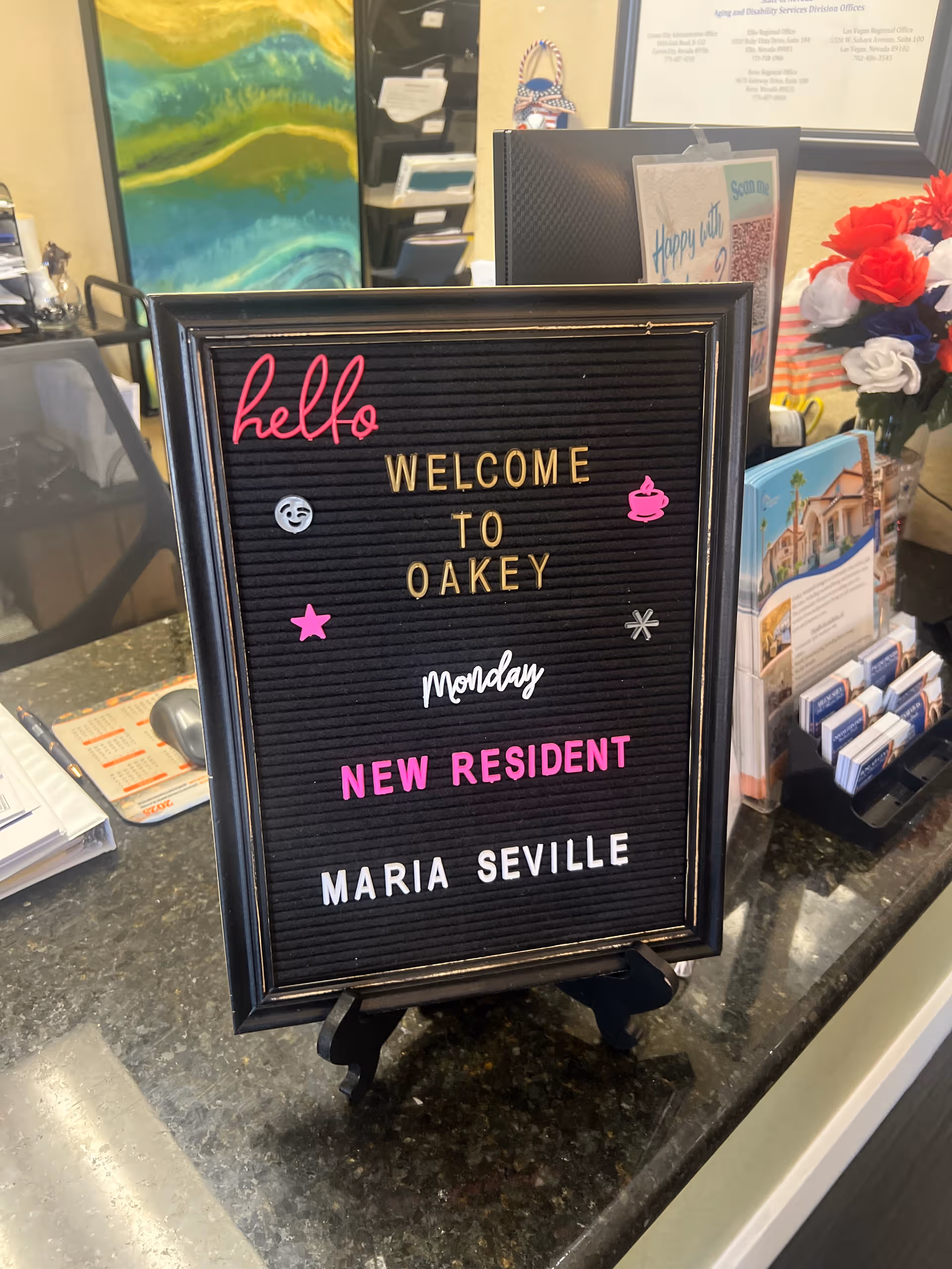 A welcome signboard on a reception counter inside Oakey Assisted Living lobby.