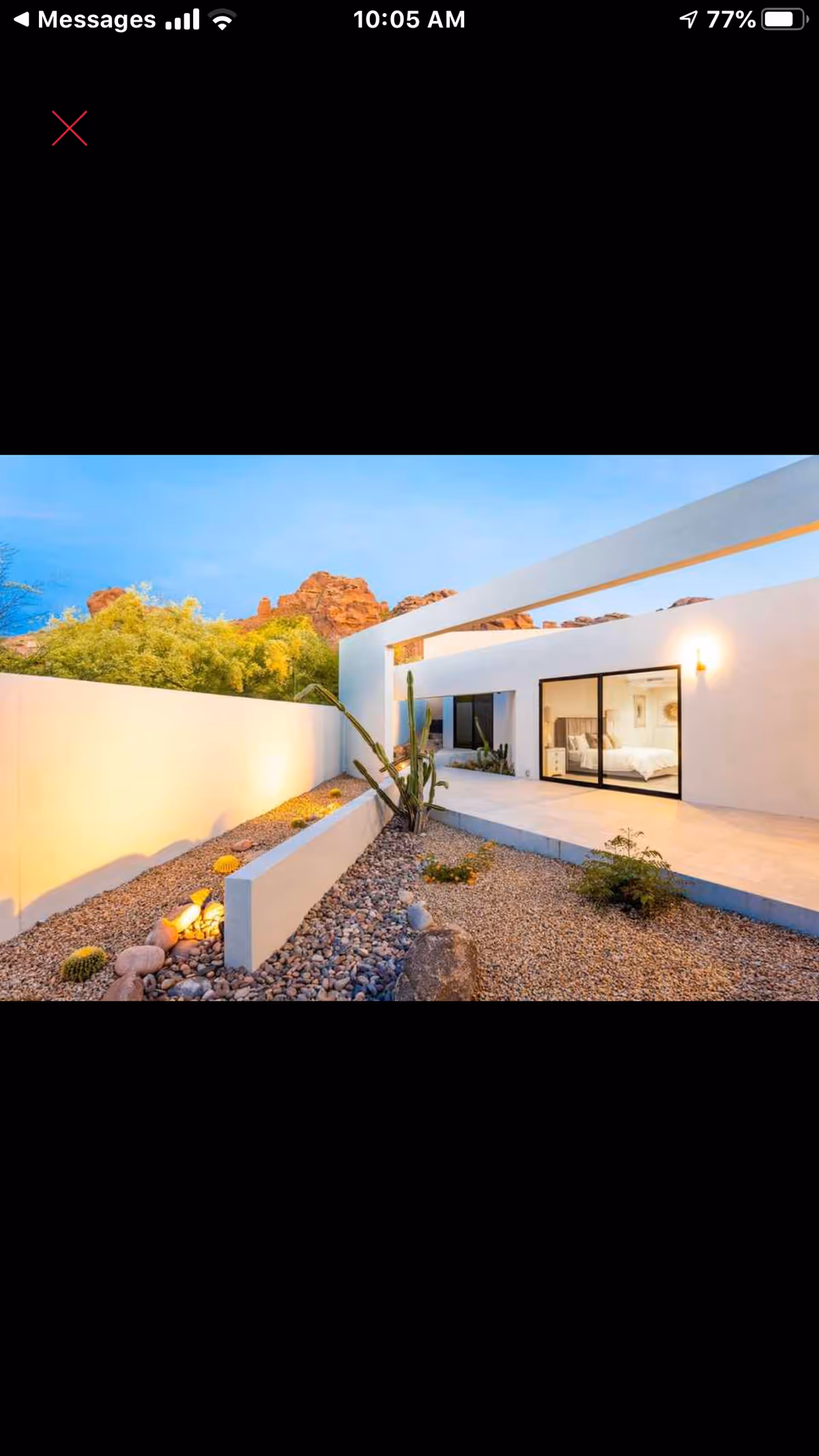 Modern white exterior with desert landscaping and a glass-entry door.