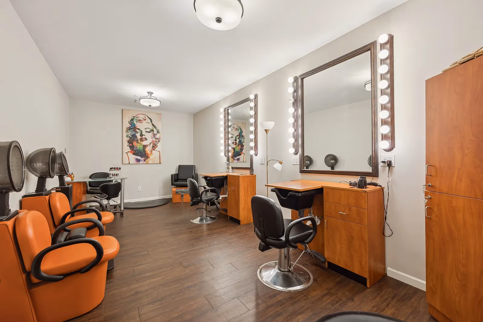 A well-lit senior living facility salon with mirrors, chairs, and styling stations.