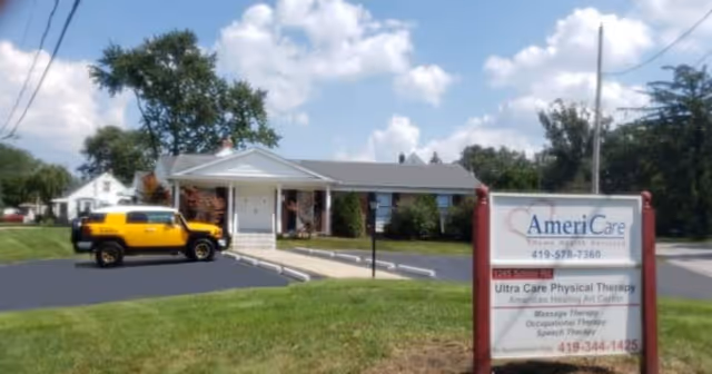Front view of AmeriCare Home Health facility with sign and parked yellow vehicle.