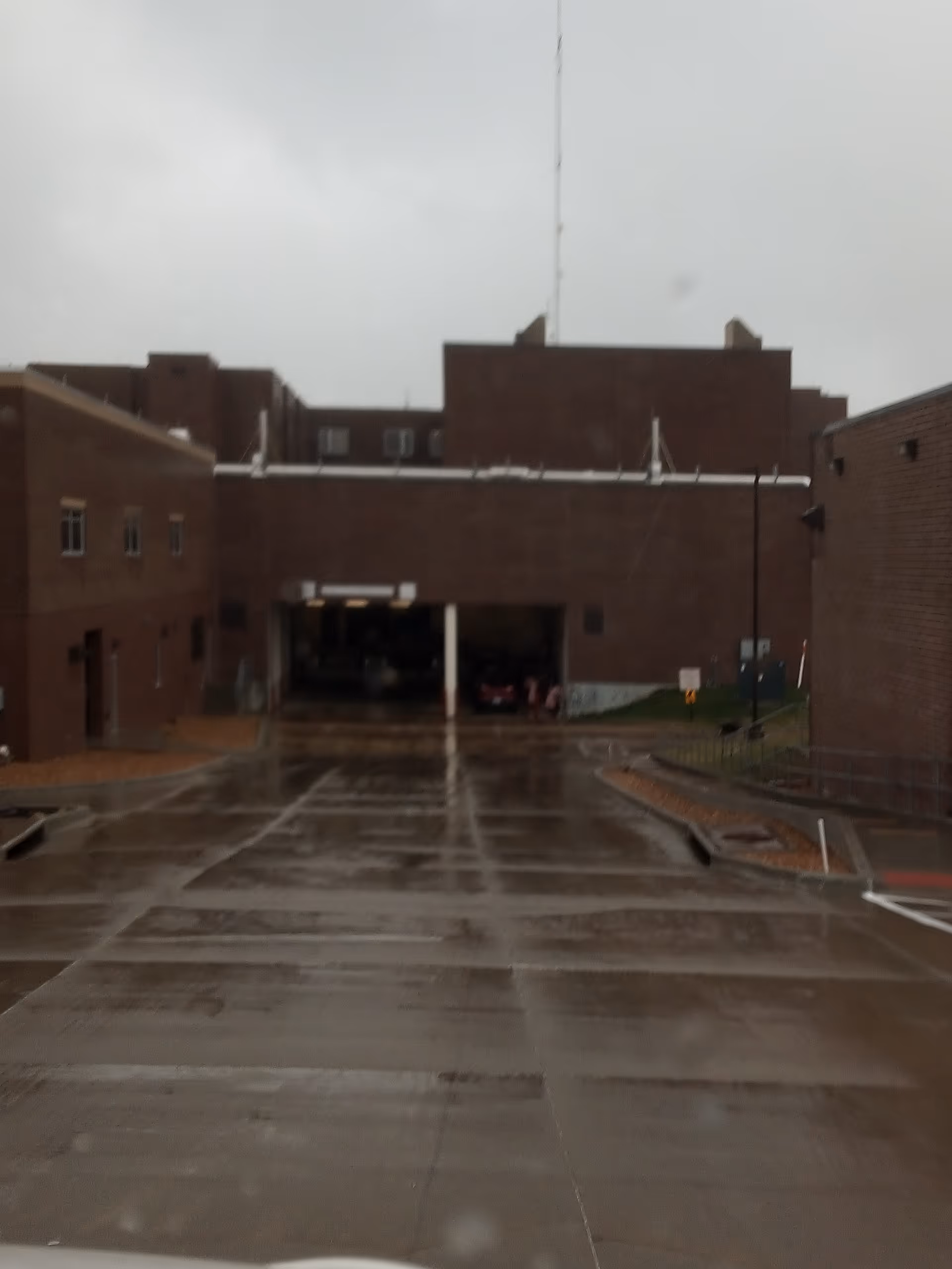 Rainy view of Golden Valley Memorial Healthcare facility front with brick buildings and entrance.