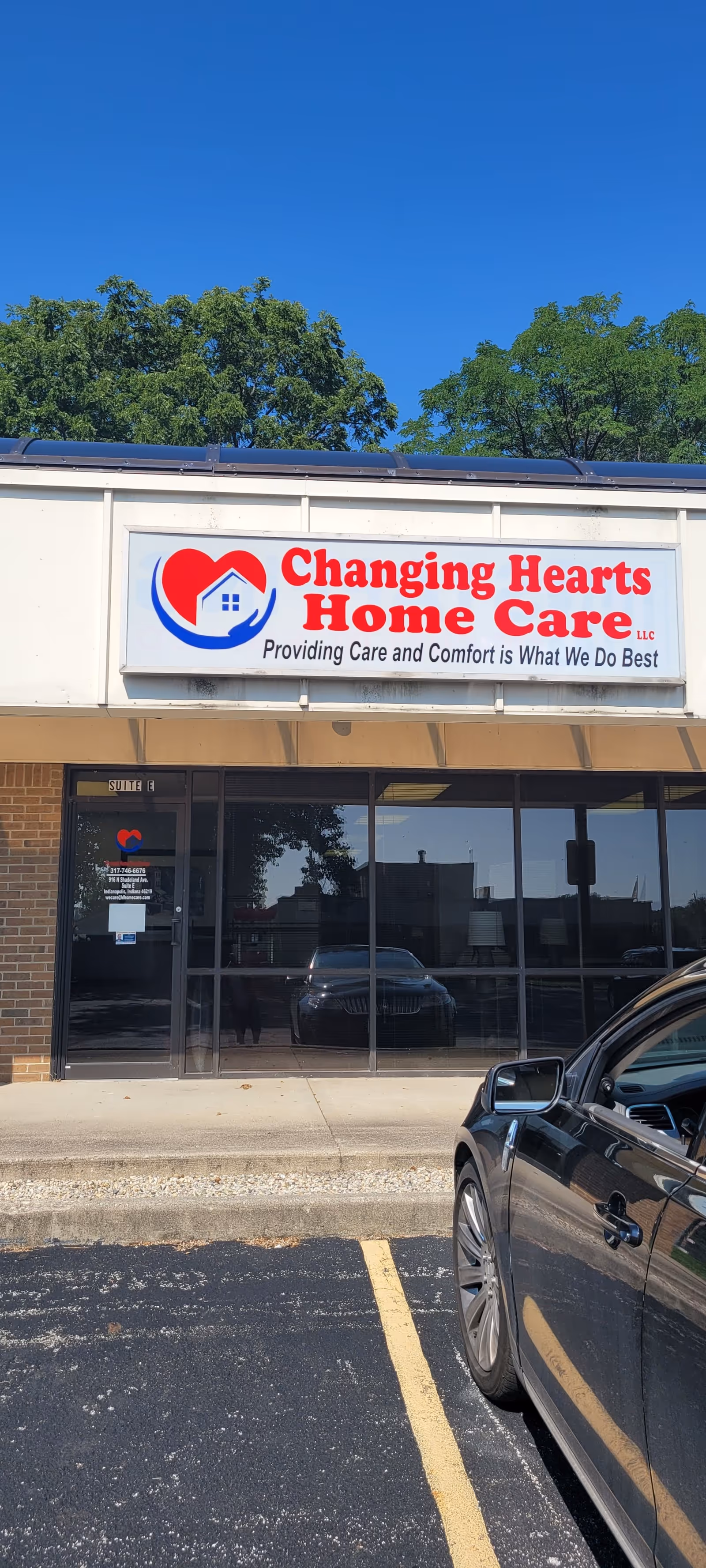 Front view of Changing Hearts Home Care building with sign and parked car.