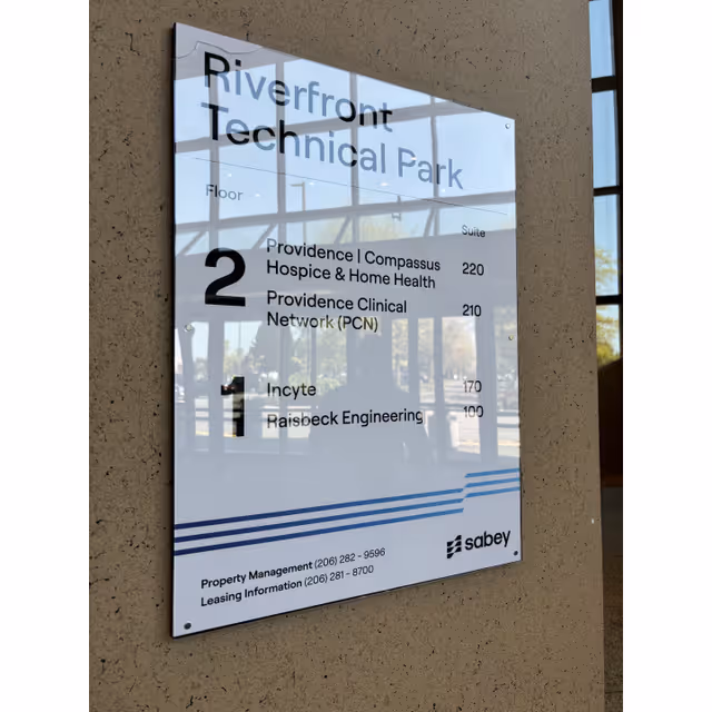 Exterior wall signboard for Riverfront Technical Park listing Providence at Home with Compassus tenants.