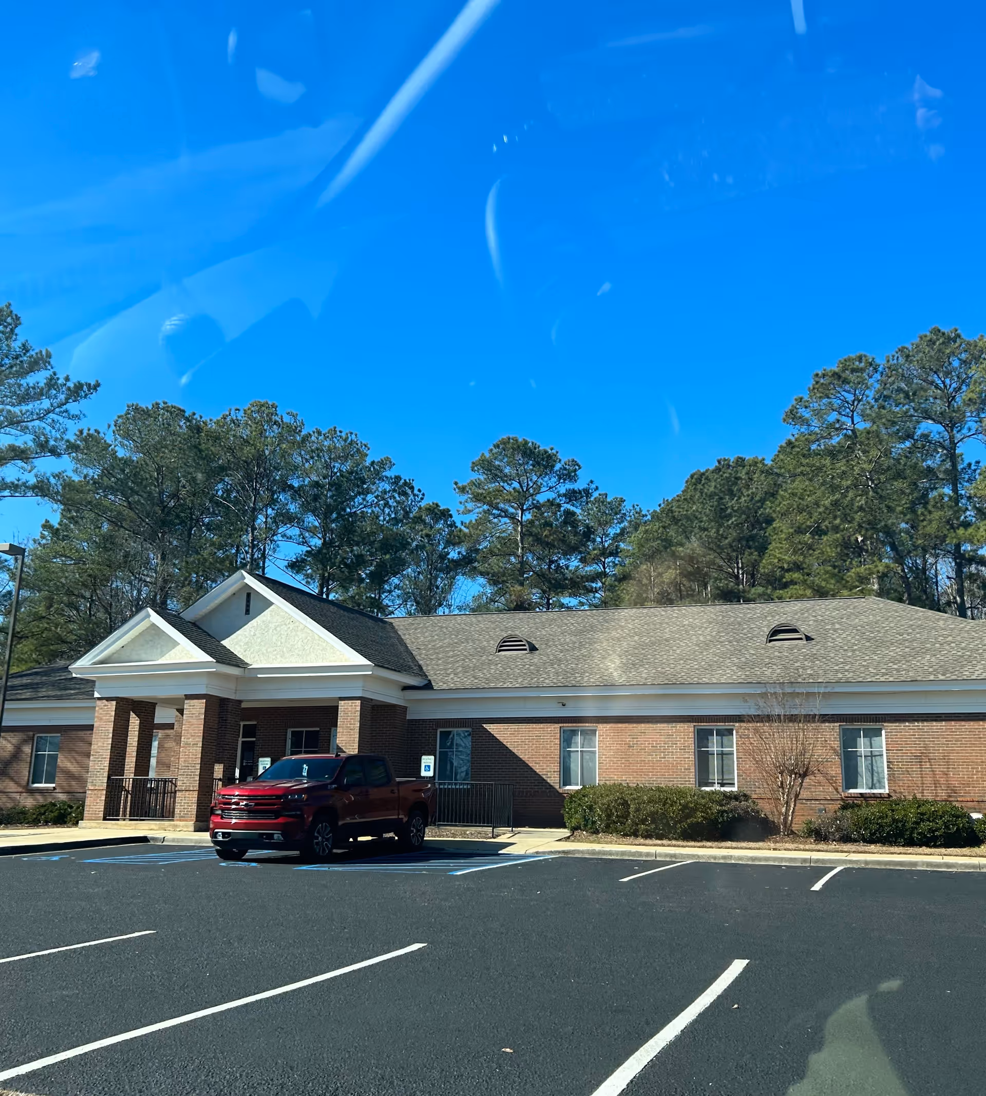 Brick health department building with a red truck in the front parking lot.