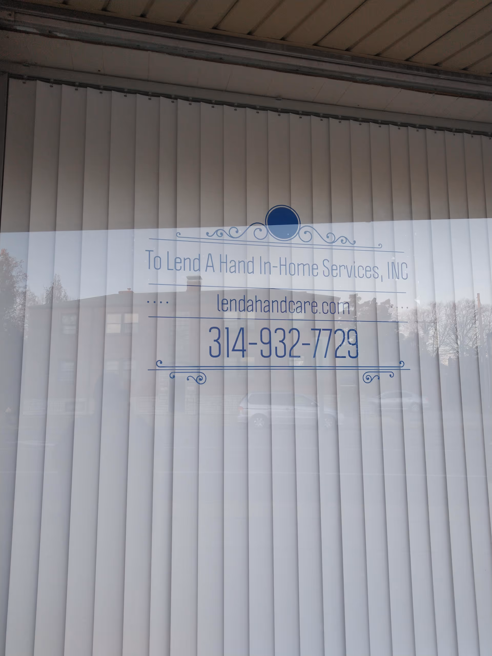 Glass storefront with blue sign reading 'To Lend A Hand In-Home Services, INC'.