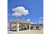 Exterior view of Elgin Nursing and Rehabilitation Center with a covered entrance and clear blue sky.