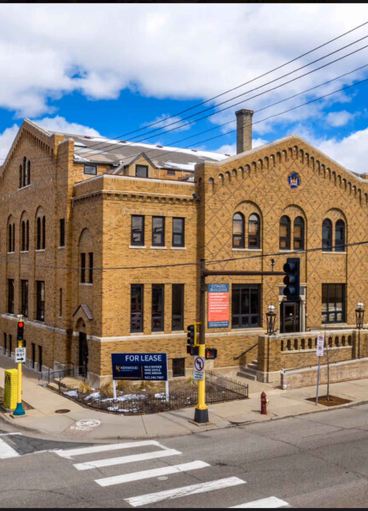 Exterior brick building with arched windows on a city street corner
